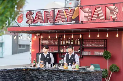 two men standing at a bar at a restaurant at The Gravitique Hotel Khaosan in Bangkok