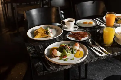 a table topped with plates of food and drinks at The Gravitique Hotel Khaosan in Bangkok