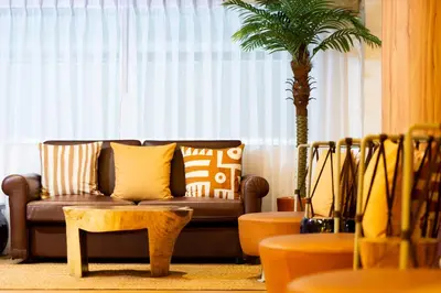 a living room with a couch and a palm tree at Arck Hotel in Bangkok