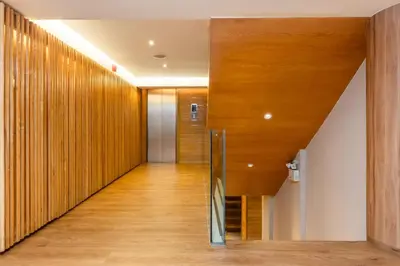 a hallway with wood paneled walls and a staircase at Arck Hotel in Bangkok