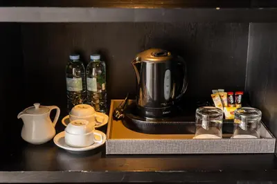 a shelf with a tea kettle and cups on it at Arck Hotel in Bangkok