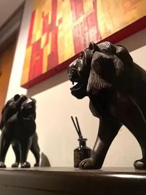 two statues of cats sitting on top of a shelf at Cafe ice resident in Yan Nawa