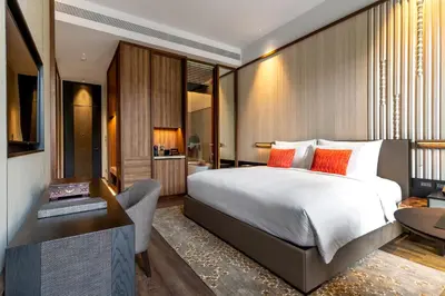 a bedroom with a bed and a desk and a chair at Villa Deva Resort & Hotel Bangkok in Bangkok