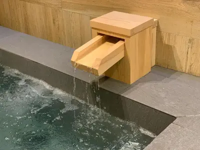 a wooden bench sitting next to a pool of water at Wellness Stay & Hotel Sukhumvit 107 in Bangna