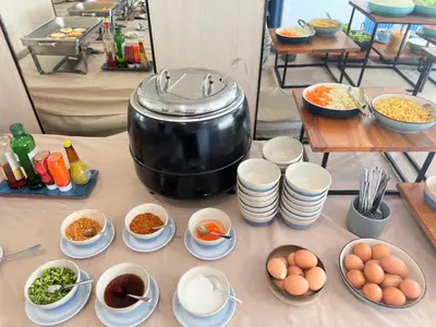 a table with a pot and plates of food at Wellness Stay & Hotel Sukhumvit 107 in Bangna