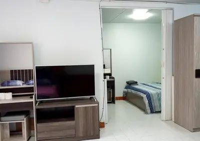 a living room with a television and a bedroom at ห้องใหญ่-ห้องพักรายวัน เมืองทองธานี เรือนศรีตรัง in Nonthaburi