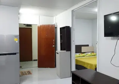 a room with a bedroom with a bed and a mirror at ห้องใหญ่-ห้องพักรายวัน เมืองทองธานี เรือนศรีตรัง in Nonthaburi