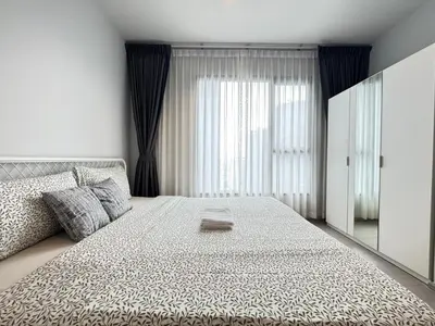 a bedroom with a large bed and a large window at Asok - Din Daeng Apartment in Bangkok