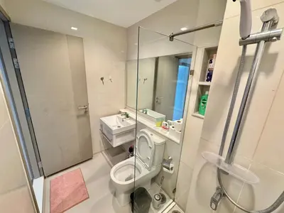 a small bathroom with a toilet and a shower at Asok - Din Daeng Apartment in Bangkok