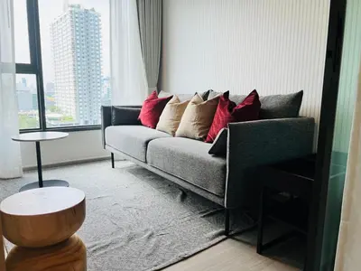 a living room with a couch and a large window at Asok - Din Daeng Apartment in Bangkok