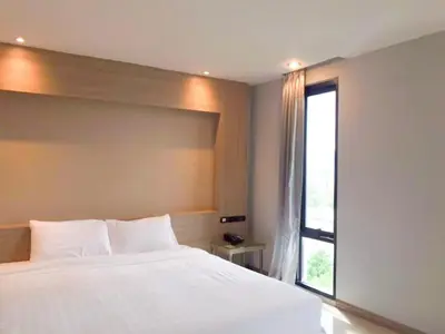 a bedroom with a large white bed and a window at C Hotel Bangna in Bangkok