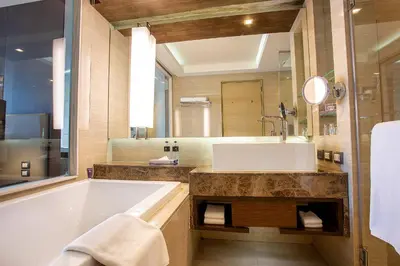a bathroom with a large tub and a large mirror at Graceland Bangkok by Grace Hotel - SHA Extra Plus in Bangkok
