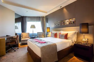 a hotel room with a large bed and a desk at Graceland Bangkok by Grace Hotel - SHA Extra Plus in Bangkok