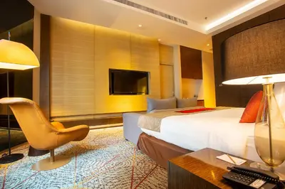 a hotel room with a bed and a desk with a computer at Graceland Bangkok by Grace Hotel - SHA Extra Plus in Bangkok