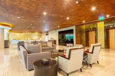 a lobby with couches and chairs in a building at Graceland Bangkok by Grace Hotel - SHA Extra Plus in Bangkok