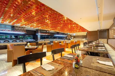 a restaurant with tables and chairs and a bar at Graceland Bangkok by Grace Hotel - SHA Extra Plus in Bangkok
