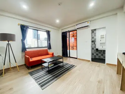 a living room with a red couch and a table at GP House Bangkok - Sukhumvit Onnut BTS Skytrain in Bangkok
