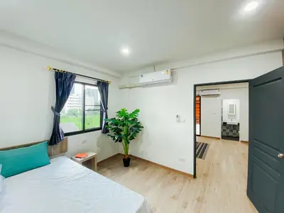 a bedroom with a bed and a plant in it at GP House Bangkok - Sukhumvit Onnut BTS Skytrain in Bangkok