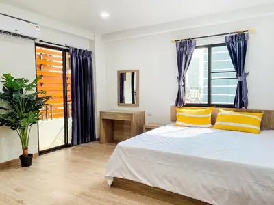 a bedroom with a bed with yellow pillows and a window at GP House Bangkok - Sukhumvit Onnut BTS Skytrain in Bangkok