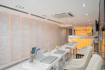 a row of tables and white chairs in a room at Masa Hotel فندق الماسة شارع العرب in Bangkok