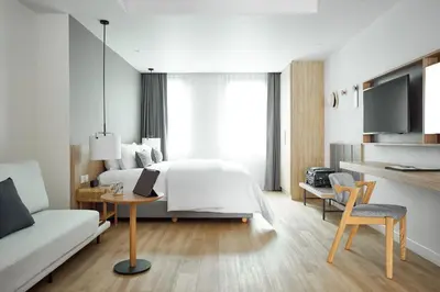 a bedroom with a bed and a table and a couch at Casa 17 Hotel Bangkok in Bangkok