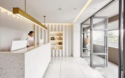a woman standing at a counter in an office with a window at Casa 17 Hotel Bangkok in Bangkok