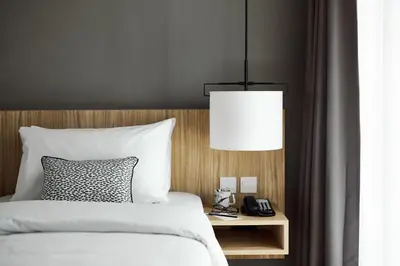 a bedroom with a bed with a lamp and a phone at Casa 17 Hotel Bangkok in Bangkok