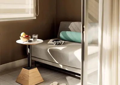 a bed with a table with a bowl of fruit on it at Casa 17 Hotel Bangkok in Bangkok