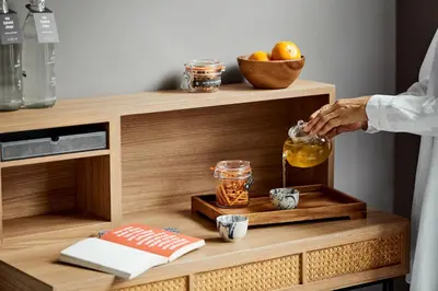a person pouring honey into a glass jar on a wooden shelf at Casa 17 Hotel Bangkok in Bangkok