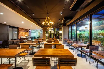 a dining room with wooden tables and chairs at Livotel Hotel Lat Phrao Bangkok in Bangkok