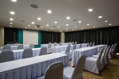 a conference room with white tables and chairs and a screen at Livotel Hotel Lat Phrao Bangkok in Bangkok