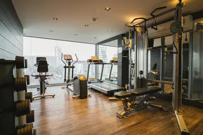 a gym with cardio equipment and a large window at VOQUE Hotel & Serviced Residence Sukhumvit 51 in Bangkok