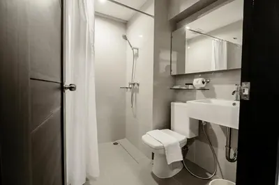 a bathroom with a toilet and a sink and a shower at UMA Residence in Bangkok