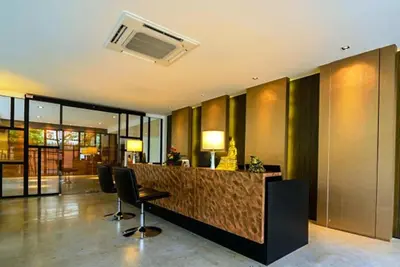 a hotel lobby with a bar with two chairs at UMA Residence in Bangkok