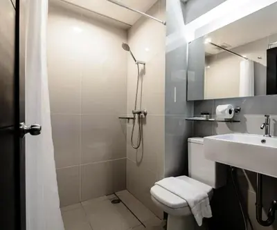 a bathroom with a shower and a toilet and a sink at UMA Residence in Bangkok
