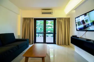 a living room with a couch and a flat screen tv at UMA Residence in Bangkok