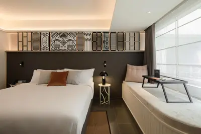 a bedroom with two beds and a table at YANH Ratchawat Hotel in Bangkok