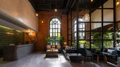 a lobby with a couch and chairs and windows at fyn park hotel in Makkasan