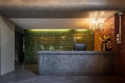 a lobby with a reception desk with green tiles at fyn park hotel in Makkasan