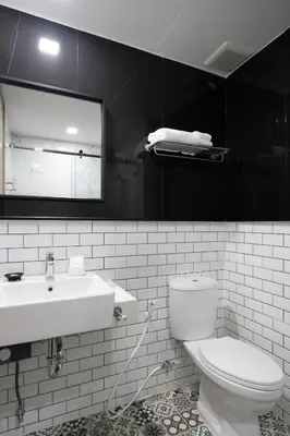 a bathroom with a sink and a toilet and a mirror at fyn park hotel in Makkasan