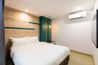 a bedroom with a white bed and a television at City Park Hotel Bangkok Pratunam by PCL in Bangkok