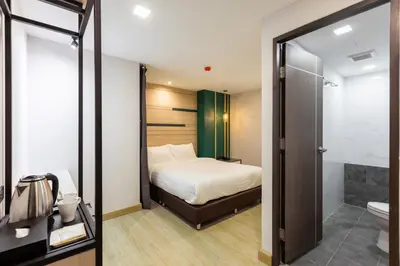 a hotel room with a bed and a bathroom at City Park Hotel Bangkok Pratunam by PCL in Bangkok