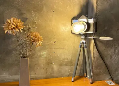 a camera on a tripod next to a vase with flowers at Central Old Town Cottage in Bangkok