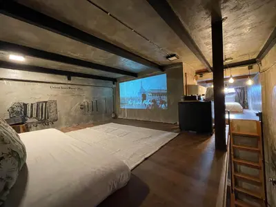 a large bed in a room with a wall with a mural at Central Old Town Cottage in Bangkok