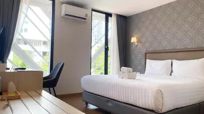 a hotel room with a bed and a large window at Lucky Hotel Bangkok in Bangkok