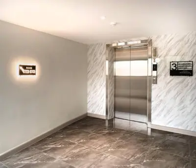 a elevator lobby with a glass door in a building at Lucky Hotel Bangkok in Bangkok