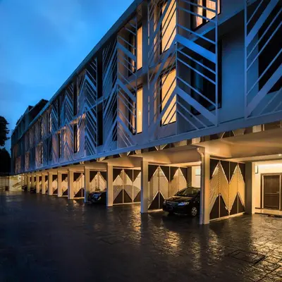 a building with a car parked in a parking lot at Lucky Hotel Bangkok in Bangkok
