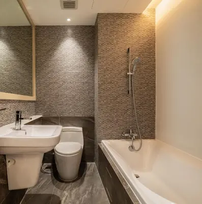 a bathroom with a toilet and a sink and a tub at Lucky Hotel Bangkok in Bangkok