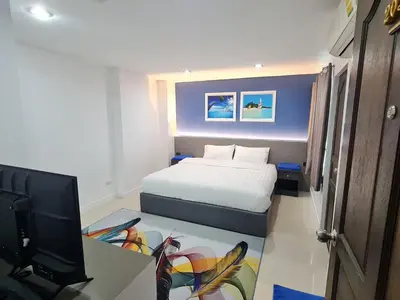a small bedroom with a bed and a television at Poonsuk Place Hotel in Bangkok Noi