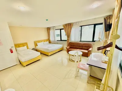 a large room with two beds and a couch at ABCYQ Hotel in Bangkok